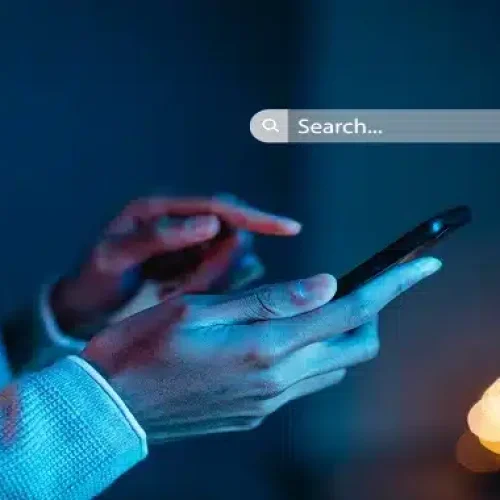 A-person-holding-a-mobile-phone-in-hand-and-a-search-box-appearing-above-his-hand